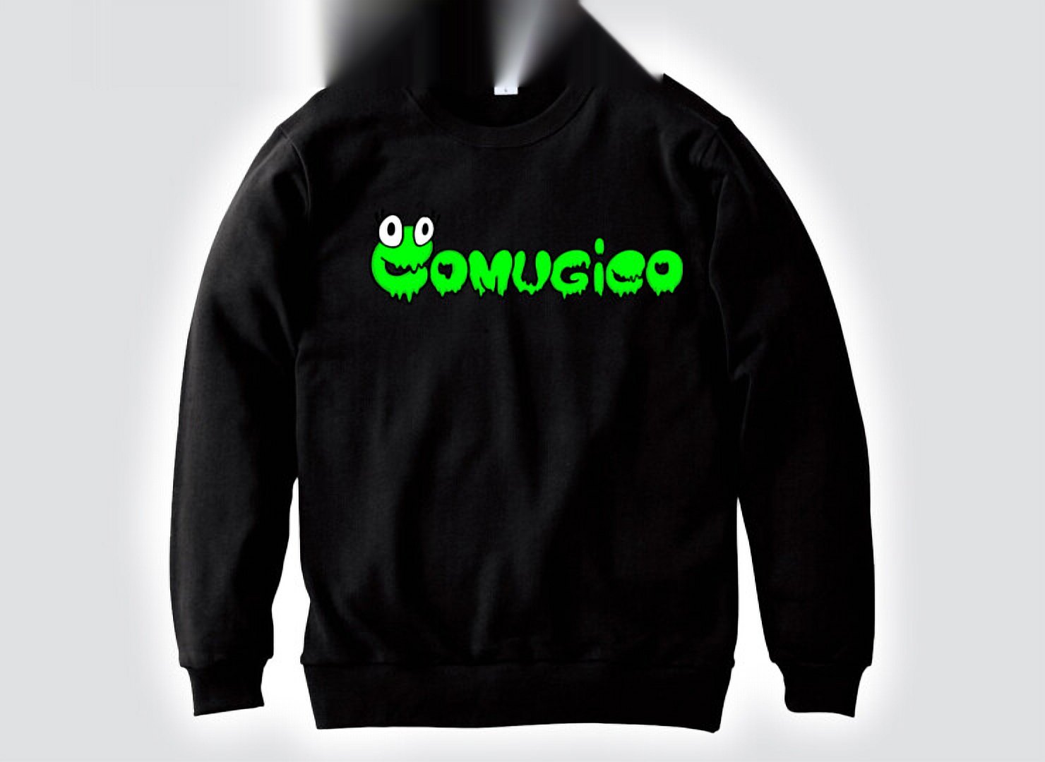 白と黒のトレーナー。胸に緑のスライム文字のCOMUGICOロゴ