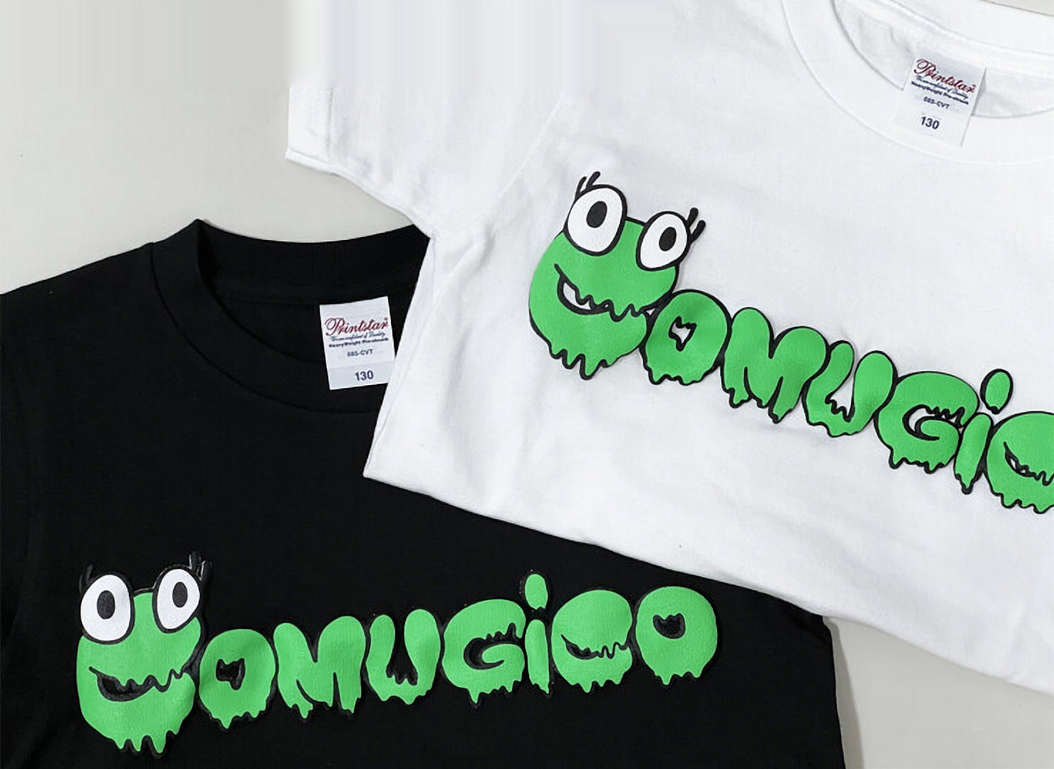 白と黒のTシャツ。胸に緑のスライム文字のCOMUGICOロゴ