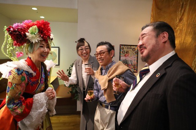 映画の場面。談笑する出演者たち
