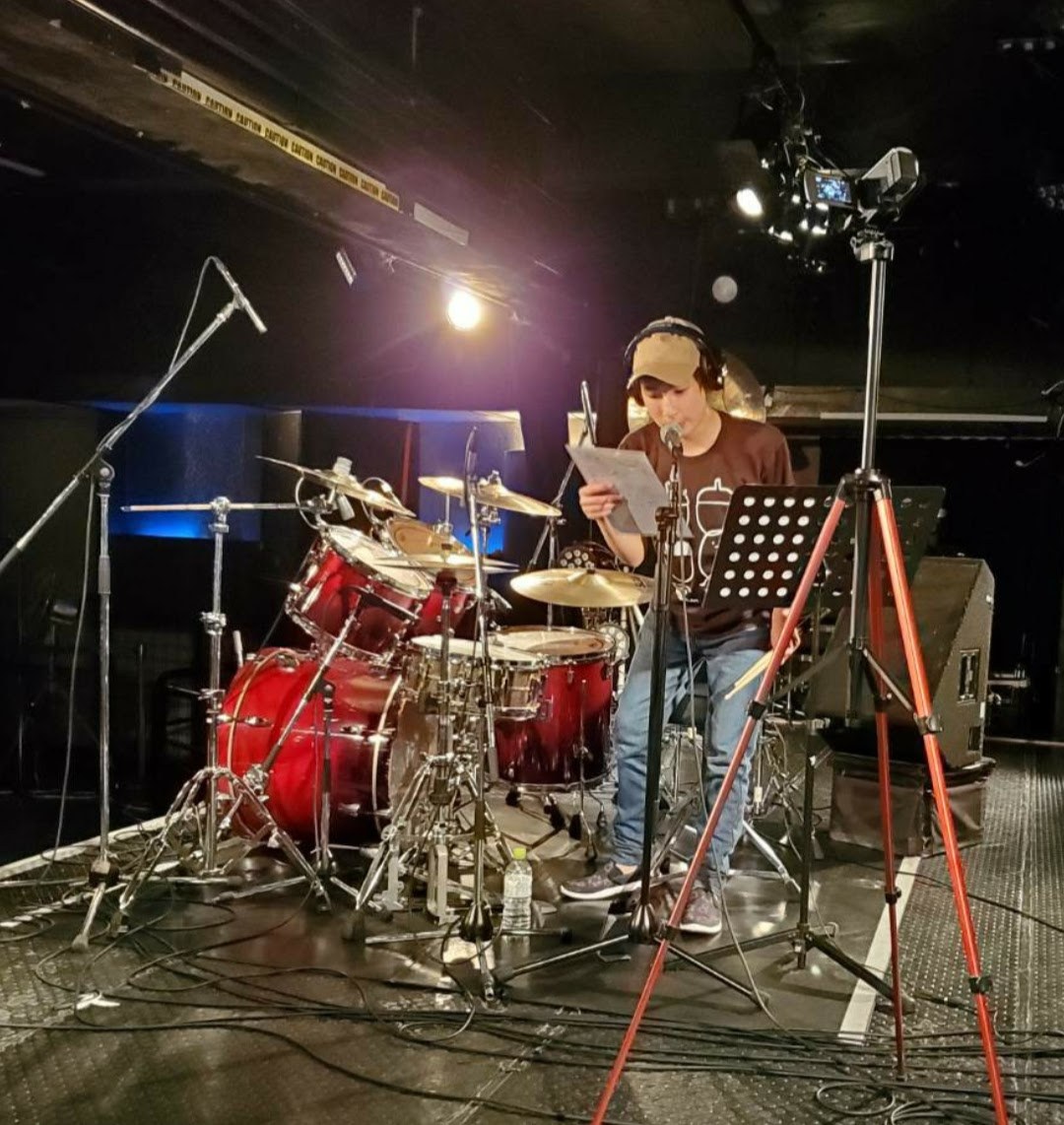 ステージでドラムの前に立つ演奏者