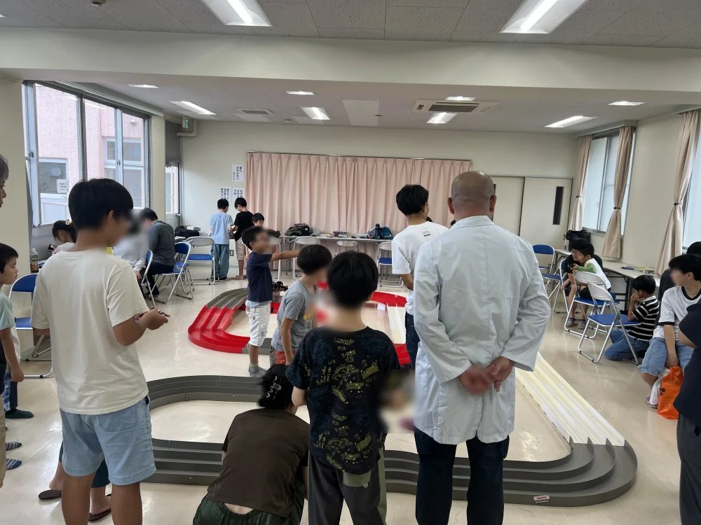 ミニ四駆教室。会場に大きなコースをつくって走らせます。