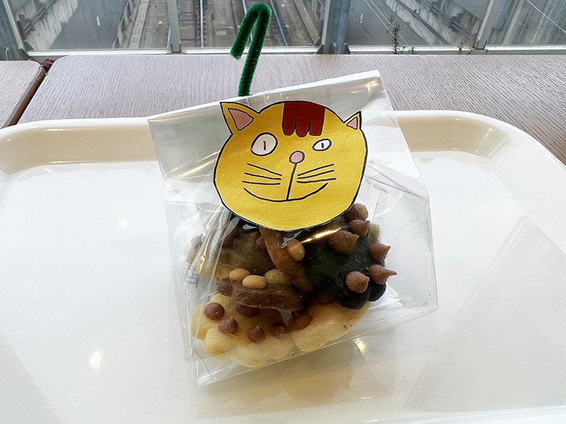 猫の顔のイラストのタグがついた、袋入りの焼き菓子