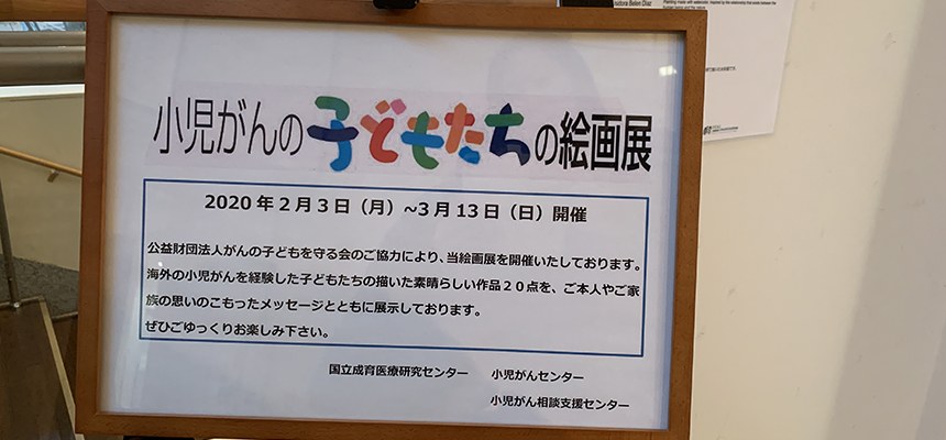 「小児がんの子どもたちの絵画展」の案内板。2020年2月3日からの会期が書かれている