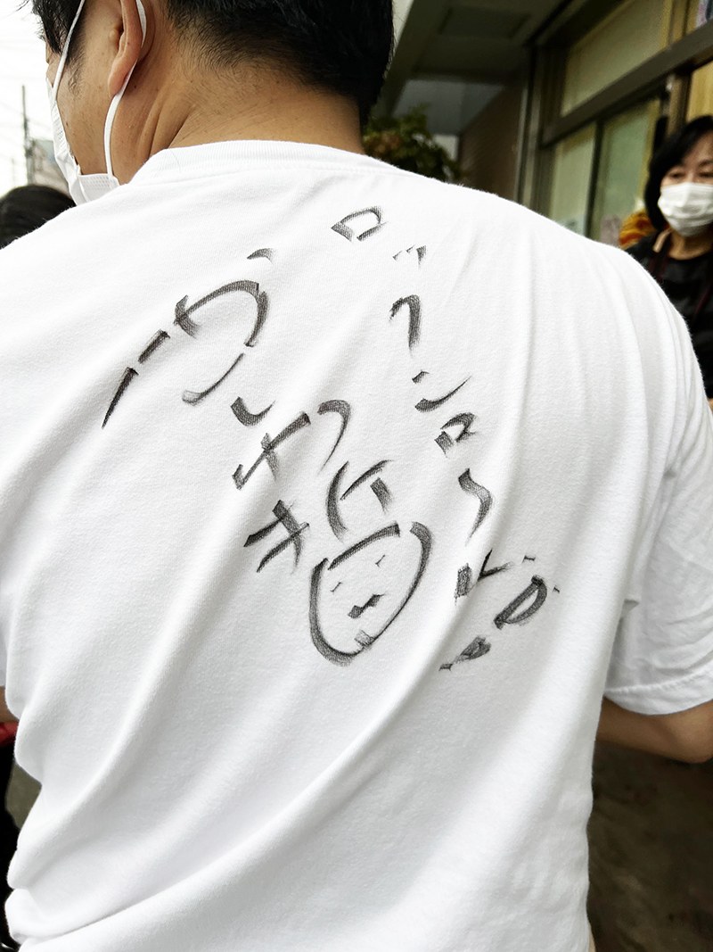 かしわ哲さんのサインと「ロックン・ロール」の文字が書かれたTシャツの背中
