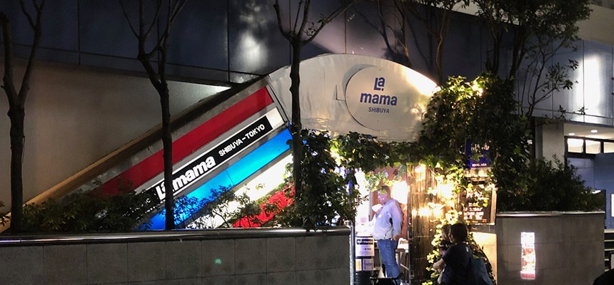 夜のライブハウスLA MAMAの入口。看板と地下へ下りる階段