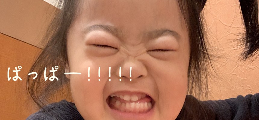 「ぱっぱー!!!!!」の文字が入った、顔をくしゃっとさせた娘のアップ
