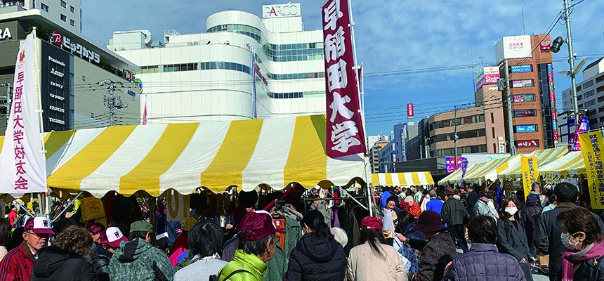黄色と白のテントが並び、大勢の人でにぎわう駅前広場の会場