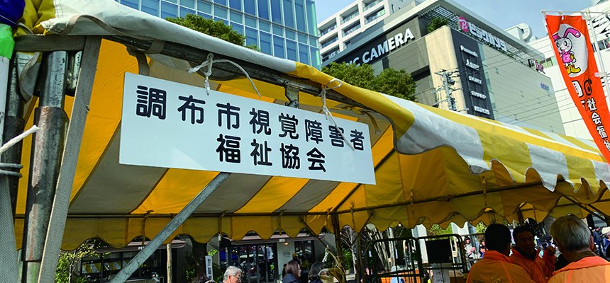 「調布市視覚障害者福祉協会」の看板がかかったテント