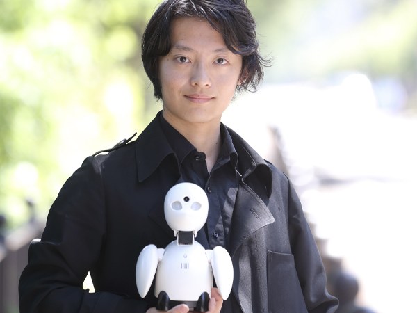 分身ロボット「OriHime」を手に持つ吉藤オリィさん