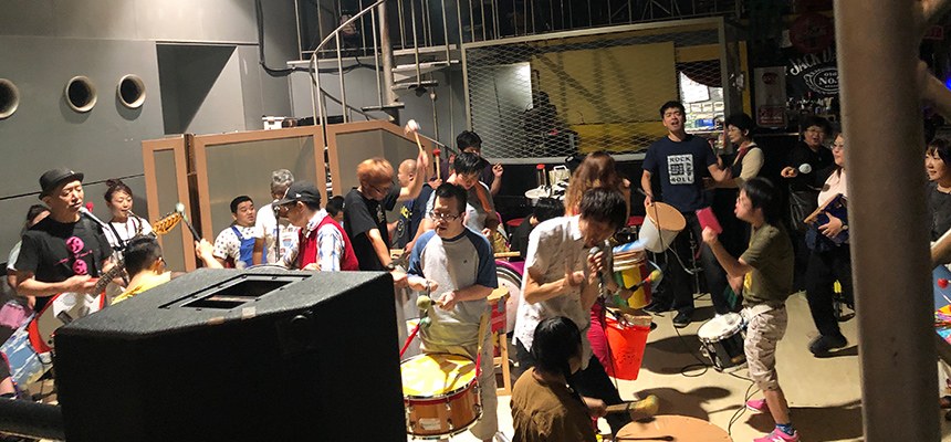 ライブハウスのフロアでガムテープドラムをたたいて盛り上がる人たち