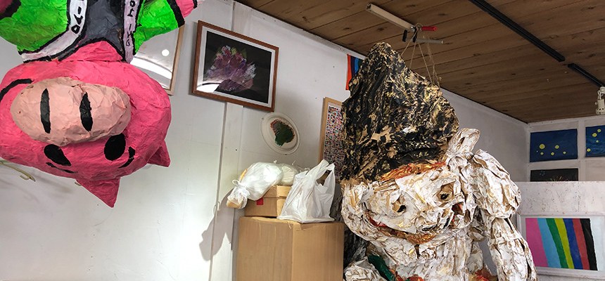 ロウテンションの室内に置かれた、ブタの顔の張り子などの作品
