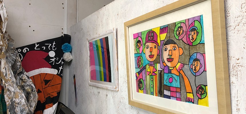 ロウテンションの壁に飾られた、カラフルな人物の絵などの作品