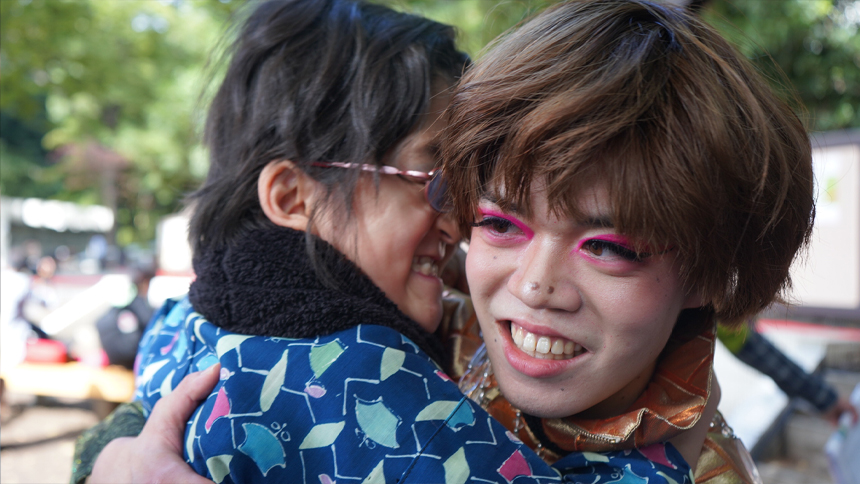 和柄の衣装を着た子どもを抱きかかえて笑うモデル