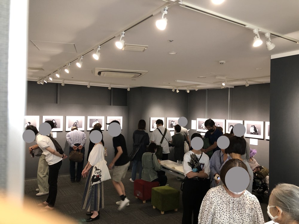 モノクロ写真が並ぶギャラリーに集まった大勢の来場者