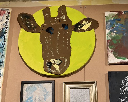 黄緑の丸の中にキリンの顔を描いた大きな作品