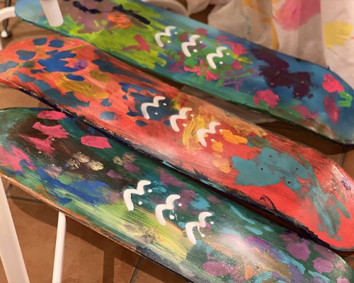 カラフルな絵の具で模様が描かれた、細長い板の作品