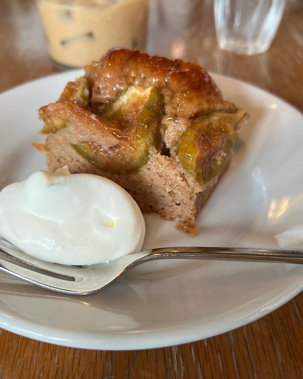 イチジクとアーモンドのケーキに白いクリームが添えられたお皿