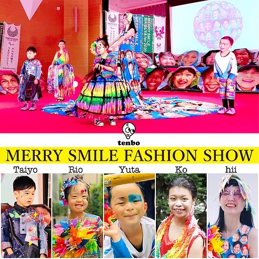 MERRY SMILE FASHION SHOW の告知。笑顔がプリントされた大きなドレスとモデルたちの写真