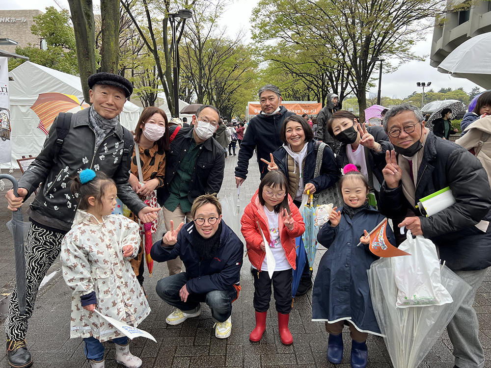 会場で大人と子どもが十数人集まって記念撮影をしている