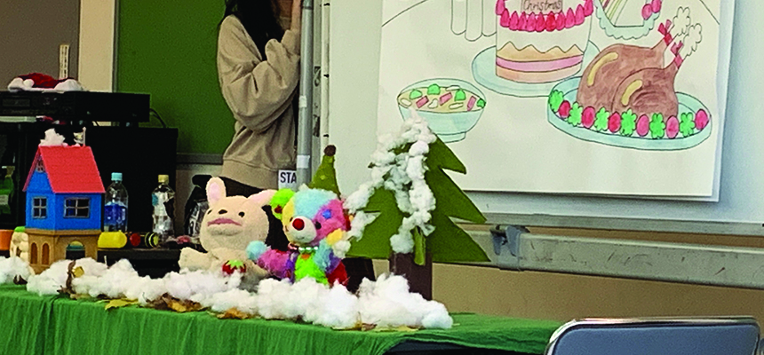 手描きの背景の前に人形やぬいぐるみが並べられた人形劇の舞台