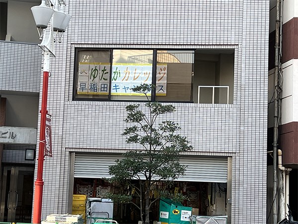 窓に「ゆたかカレッジ 早稲田キャンパス」の看板が掲げられたビル